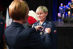 Przedstawicielka Wojewody dolnośląskiego przypina medal policjantce.