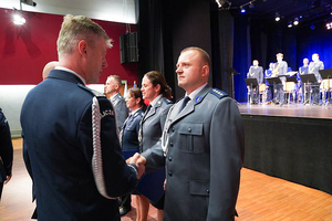 Komendant Wojewódzki Policji we Wrocławiu nadinspektor Dariusz Wesołowski gratuluje odznaczonemu policjantowi stojącemu w szeregu.