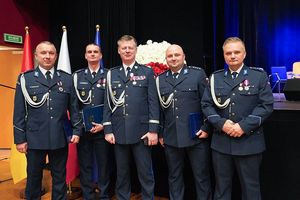 Komendant Wojewódzki Policji we Wrocławiu nadinspektor Dariusz Wesołowski na wspólnym zdjęciu z czterema odznaczonymi policjantami.