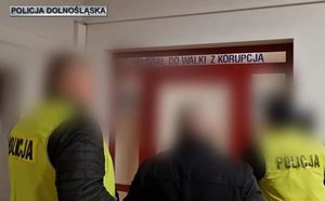 Dwaj policjanci prowadzą zatrzymanego