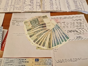 dowody rejestracyjne pojazdów i banknoty leżące na stole