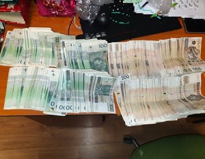 Rozłożone banknoty 100 i 200 złotowe na stole.