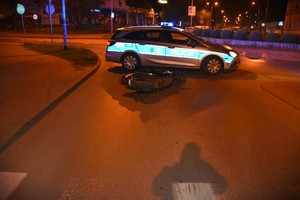 Przewrócony motor obok radiowozu