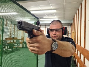 Policjant podczas konkursu strzela na strzelnicy