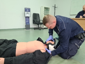 Policjant podczas udzielania pierwszej pomocy w ramach konkursu