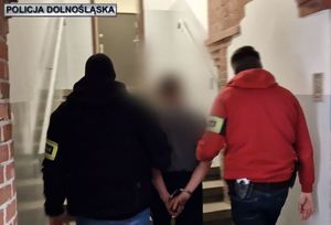 dwaj policjanci prowadzą zatrzymanego