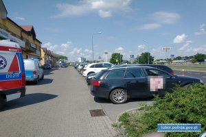 Samochód z którego uratowano dziewczynkę, na parkingu z boku radiowóz policyjny i karetka pogotowia