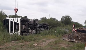 Na zdjęciu przewrócony na bok ciągnik siodłowy wraz z naczepą który osunął się do rowu, co spowodowało wywrócenie całego składu - widok z przodu.