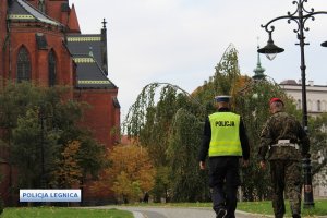 Policjant i żołnierz patrolują ulice miasta.