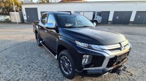 Na zdjęciu nieoznakowany nowy radiowóz pickup marki Mitsubishi L200 koloru czarnego.