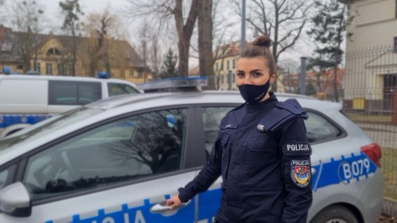 policjantka stojąca koło radiowozu