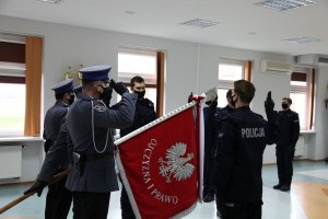Na zdjęciu widać nowych policjantów składających przysięgę ślubowania. Widać również sztandar jednostki.