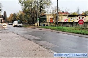 Na zdjęciu widać przejazd kolejowy z zaporą. w tle widać inne pojazdy