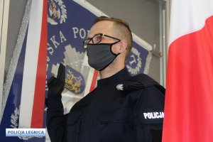 policjant podczas ślubowania stoi koło sztandaru