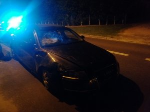 Na zdjęciu widać uszkodzone auto osobowe a w tle świecące niebieskie światło błyskowe