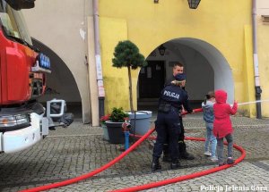 Policjantka i strzał pokazują dzieciom sprzęt służbowy