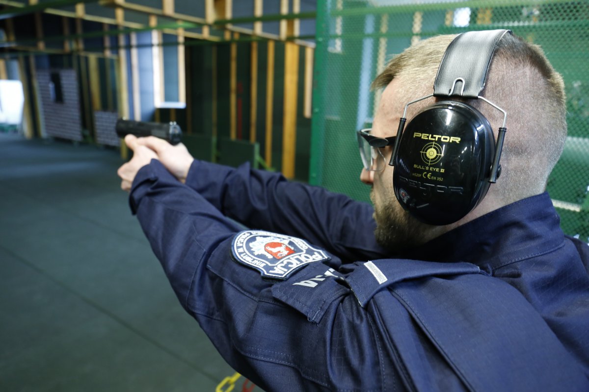 Policjant strzela do tarczy z broni