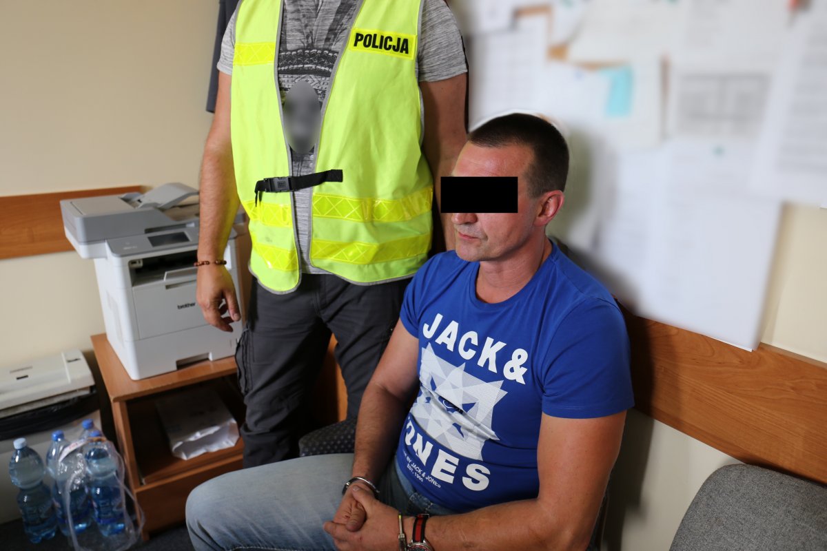 Zatrzymany mężczyzna, obok stoi policjant.