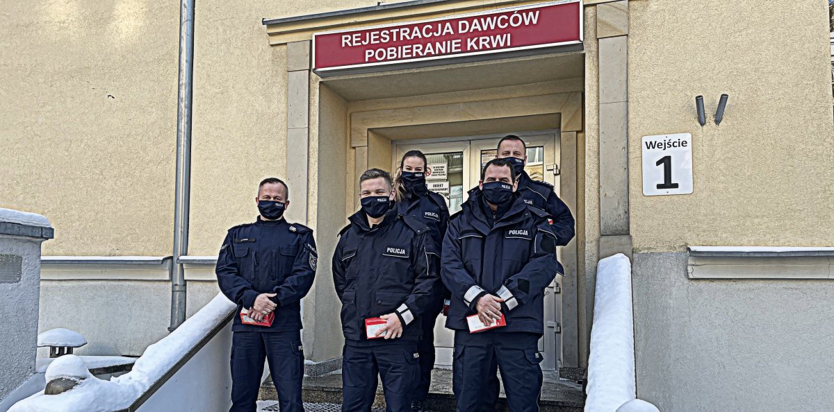 Policjanci, którzy oddali krew na tle budynku.