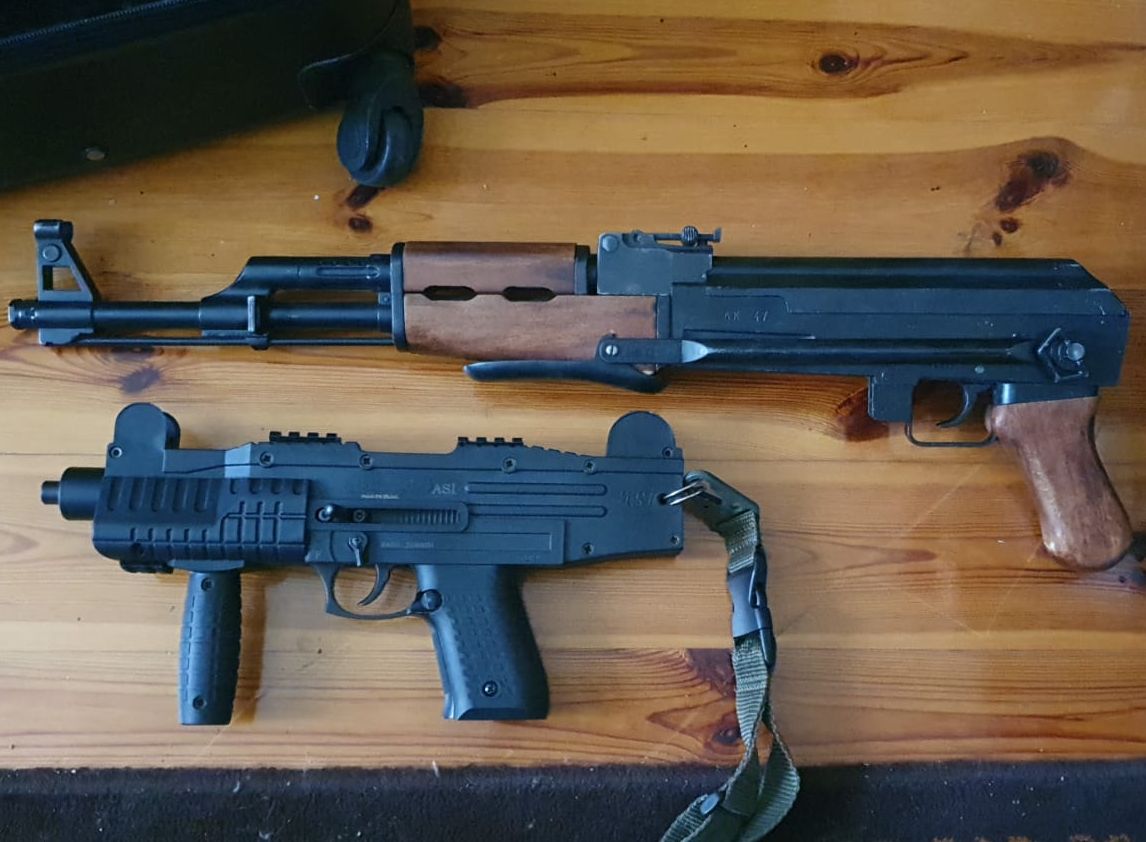 dwa pistolety maszynowe leżące na stole 