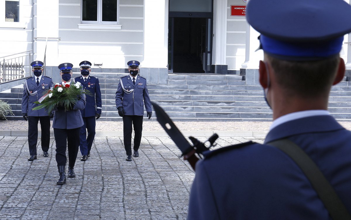 składanie wiązanki przez policjantów pod pomnikiem tablicą