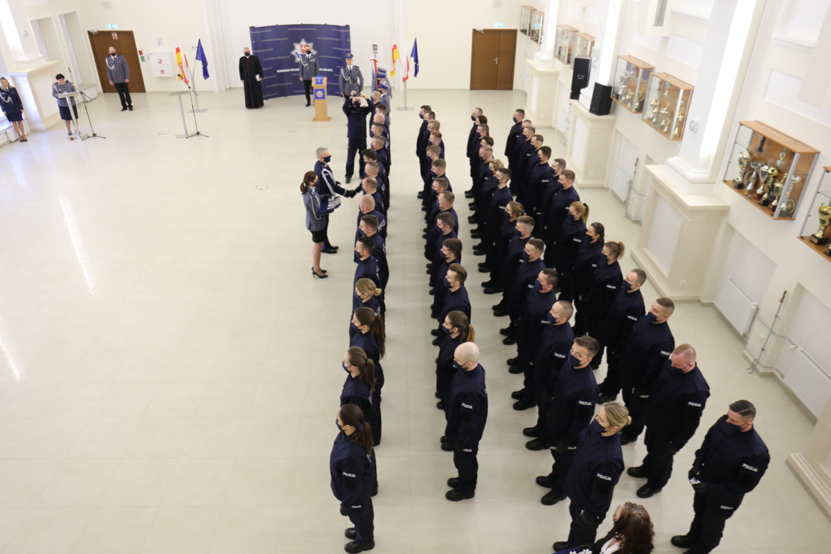 Zdjęcie wykonane z góry na salę w której odbywa się wręczanie legitymacji nowym policjantom.