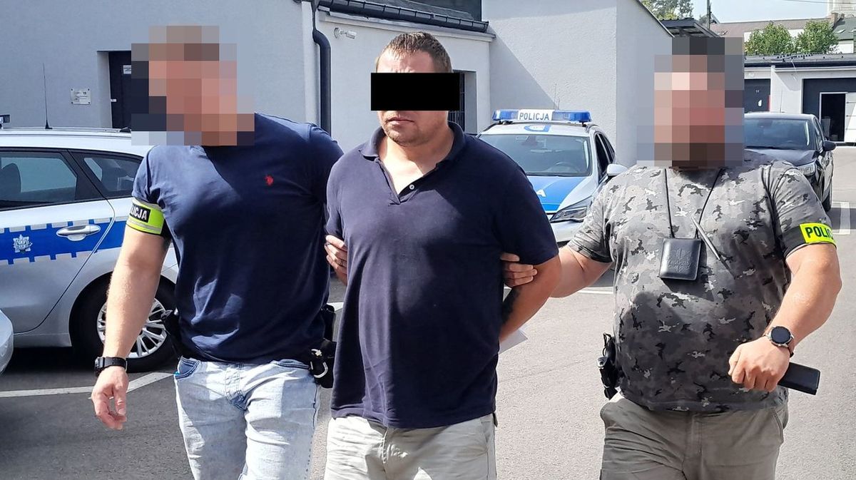 policjanci prowadzą zatrzymanego oszusta