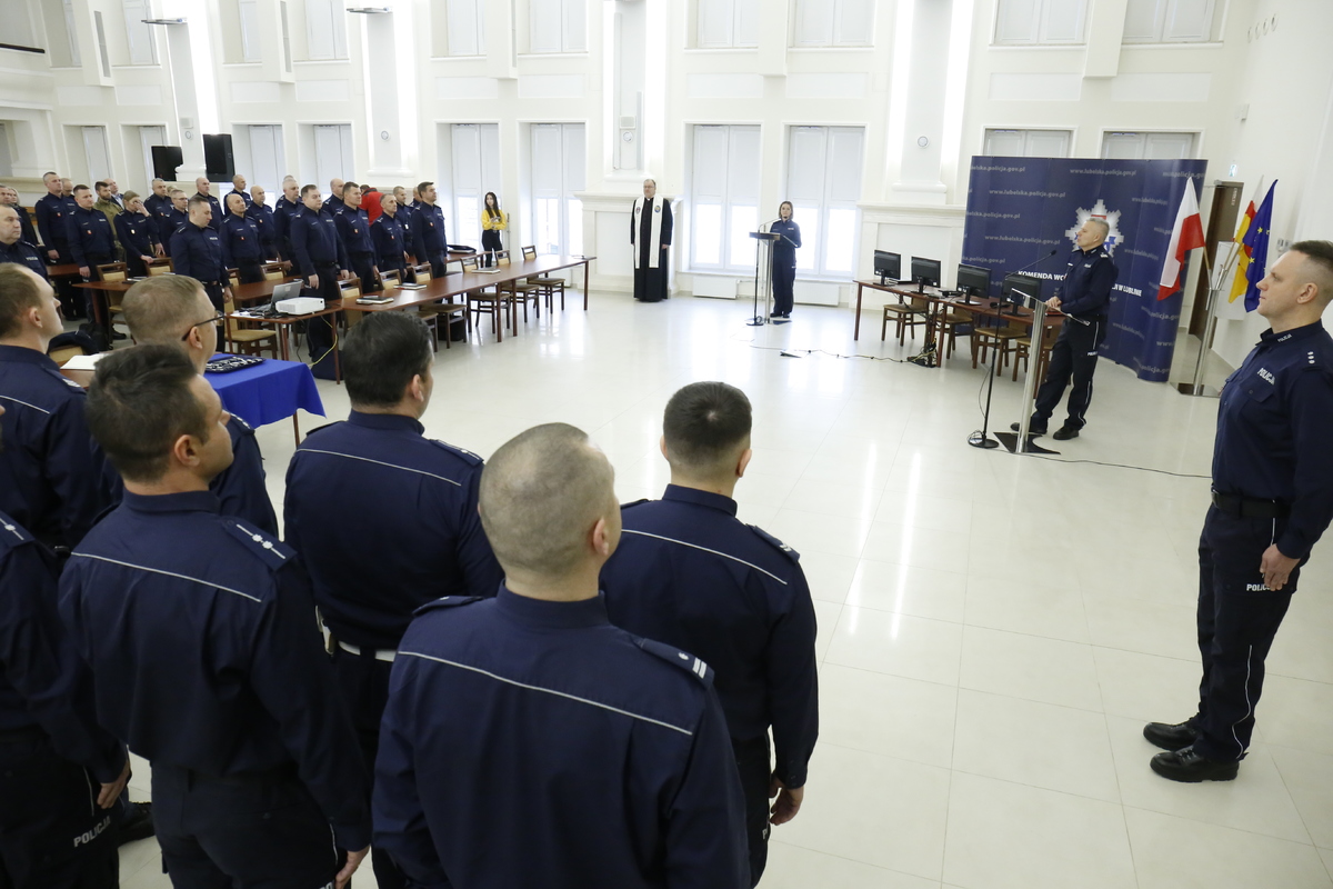 Na zdjęciu widzimy dużą salę odpraw na której jest kadra kierownicza Lubelskiej Policji oraz funkcjonariusze oczekujący na odbiór kluczyków do nowych radiowozów.