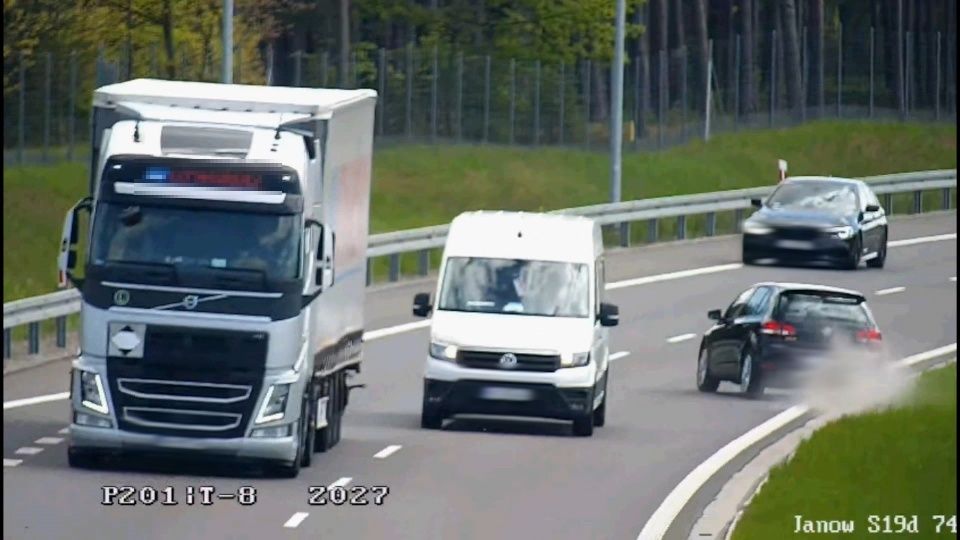 Zdjęcie przedstawia auto osobowe koloru czarnego, które jedzie pod prąd drogą ekspresową.