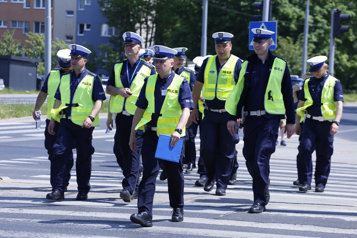 Policjanci z Wydziału Ruchu Drogowego przechodzą przez przejście.