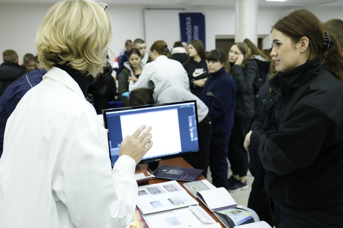 Specjaliści z policyjnego  laboratorium prezentują sposoby sprawdzenia autentyczności dokumentów.