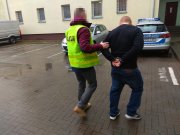 zatrzymany mężczyzna doprowadzany przez policjanta