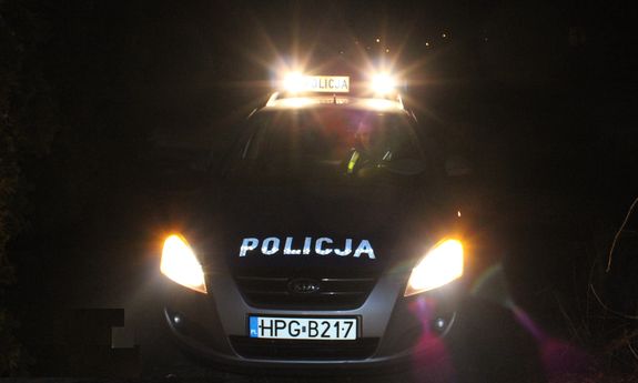 radiowóz nocą, w środku policjant