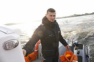 policjant na łodzi trzyma kapok