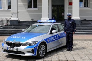 policjanci stojący na baczność przy radiowozach