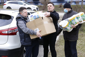 Pracownik Komendy Wojewódzkiej Policji w Lublinie i wolontariusze niosą dary dla uchodźców.