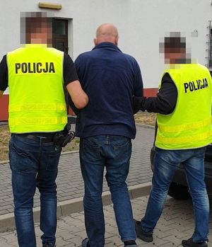 policjanci prowadzą zatrzymanego mężczyznę