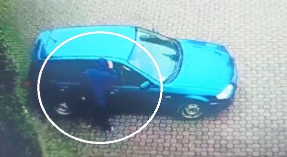 38 letni mężczyzna zagląda do wewnątrz auta przez szybę.