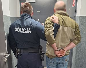 policjant prowadzi zatrzymanego mężczyznę