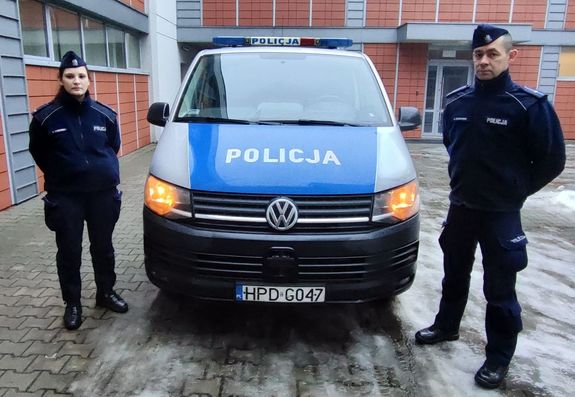 policjantka i policjant przy radiowozie busie