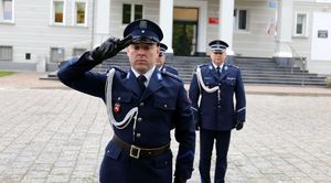 policjant oddaje honor przed pomnikiem