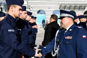 Wiceminister i komendant wojewódzki gratulują policjantom.