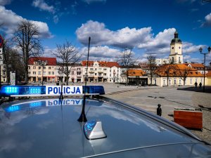 Dach radiowozu zaparkowanego na placu miejskim w Białymstoku. W tle ratusz.