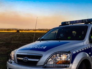 Palące się łąki w Biebrzańskim Parku Narodowym.  Na pierwszym planie radiowóz.