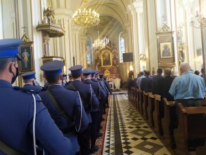 poczet sztandarowy i kompania reprezentacyjna stoją w Parafii Zwiastowania Najświętszej Maryi Panny w Dobrzyniewie; w tle ołtarz; w nawie bocznej stoją m.in. policjanci
