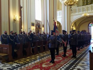 policjanci z pocztu sztandarowego oddają honor szablą