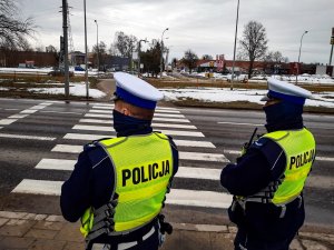 Policjanci stoją przy przejściu dla pieszych.