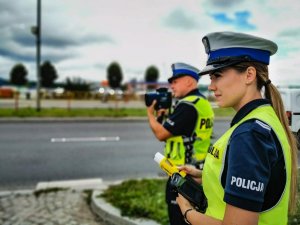 Policjantka stoi przy drodze.