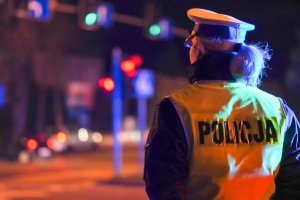 Policjantka przy drodze nocą.