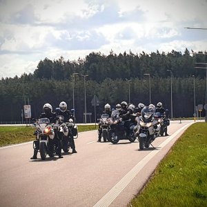 Grupa policyjnych motocyklistów na drodze.